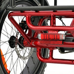 Close-up of a red motorcycle frame with visible suspension and wheel. #color_red