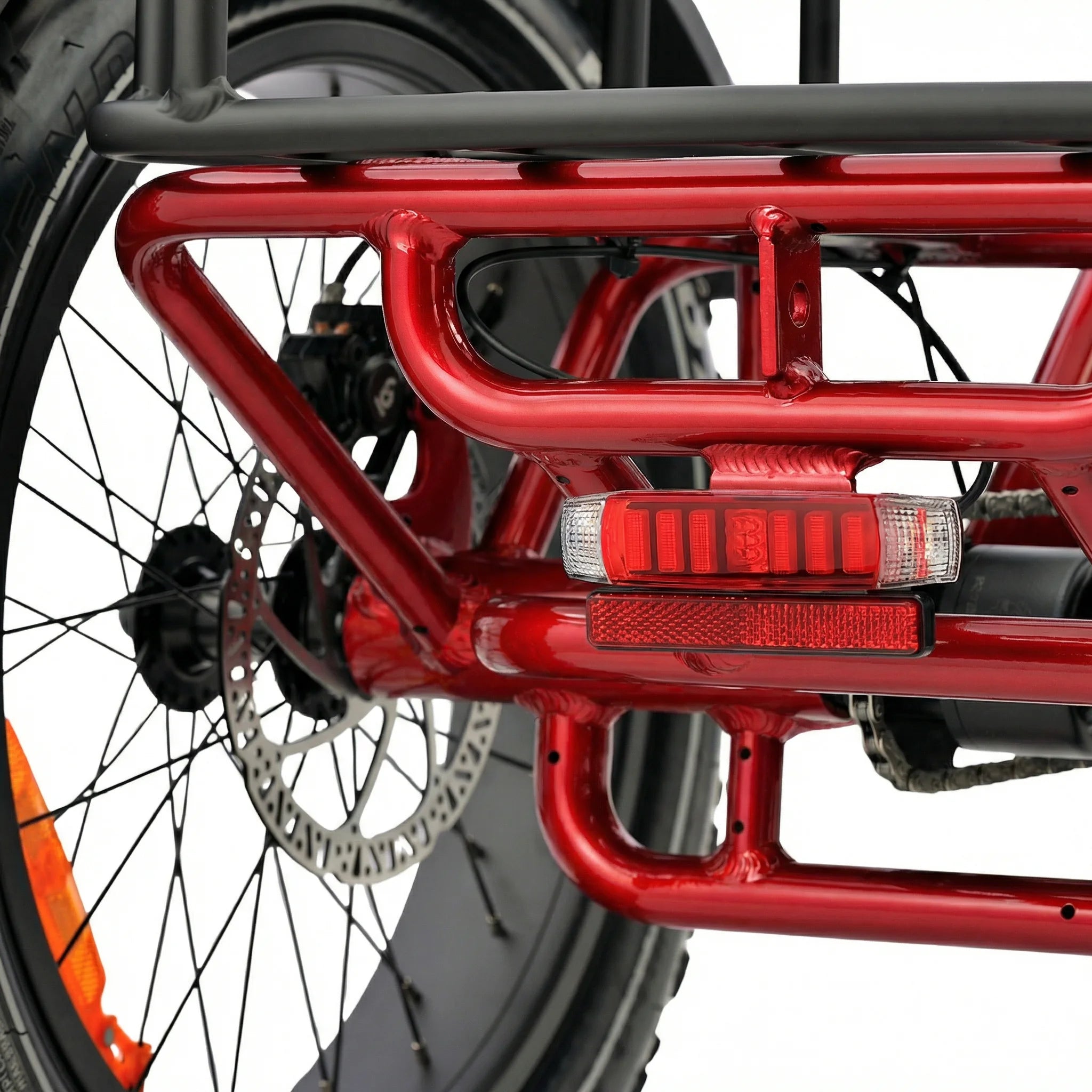 Close-up of a red motorcycle frame with visible suspension and wheel. #color_red