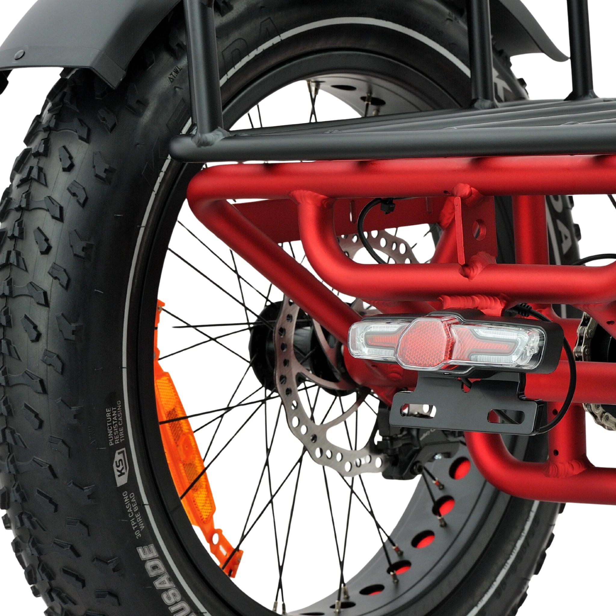 Close-up of a red bicycle frame with a black tire and orange rim on a white background