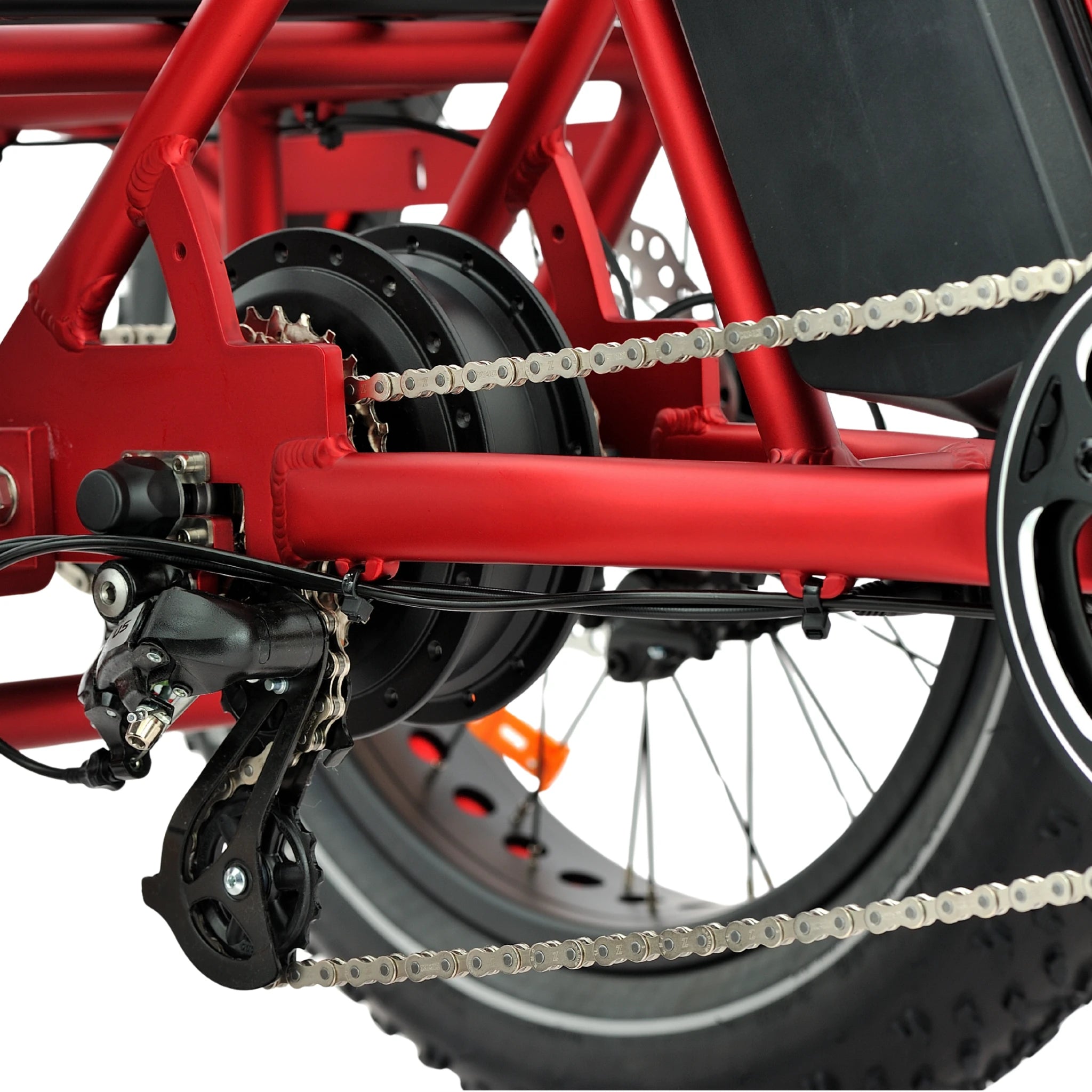 Close-up of a red electric bike's chain and gear system on a white background
