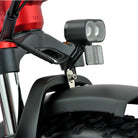 Close-up of a motorcycle headlight and front fender on a white background